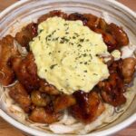 chicken nanban in a bowl of shredded cabbage topped with tartar sauce