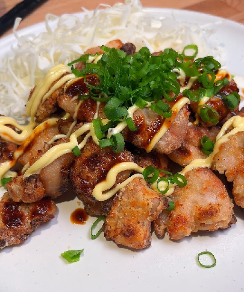 airfried chicken served on plate topped with green onions and japanese mayo
