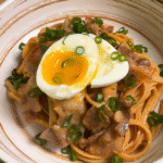 creamy miso pasta serve in plate, topped with soft boiled egg