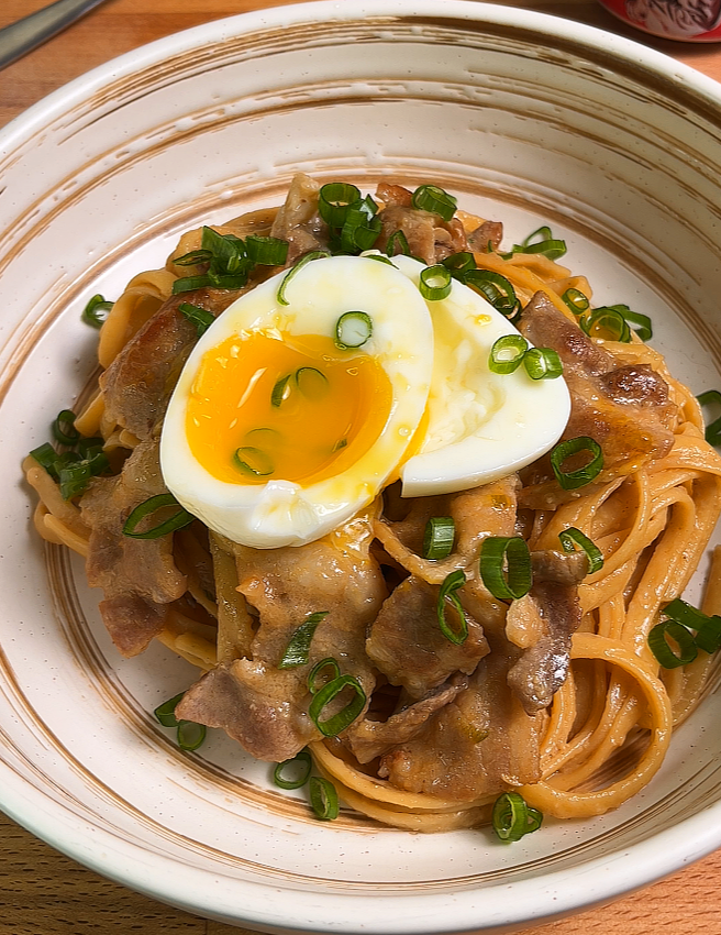 creamy miso pasta serve in plate, topped with soft boiled egg