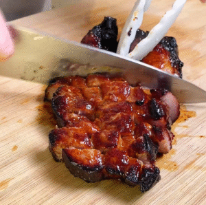 charred char siu being cut and served