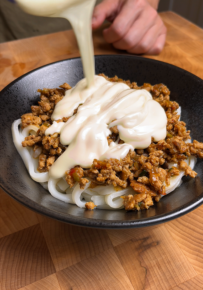pouring tofu sauce on udon